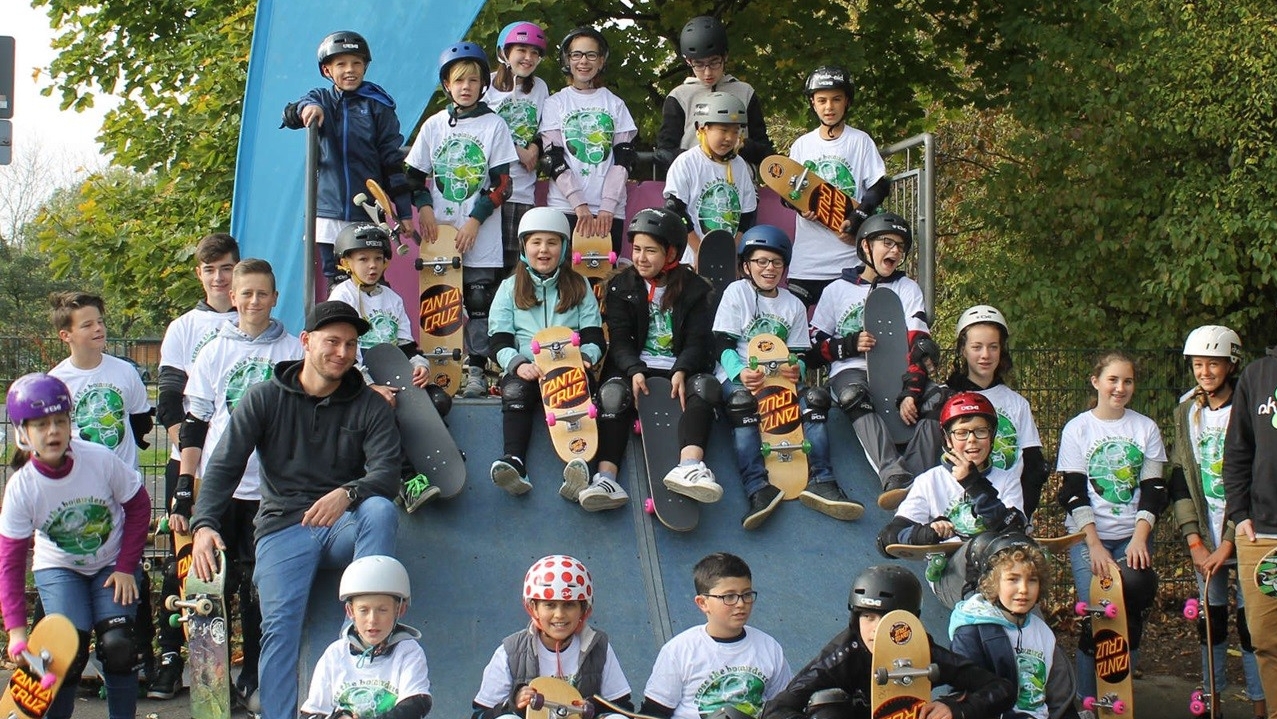Viele Kinder, die Skateboards in der Hand haben.