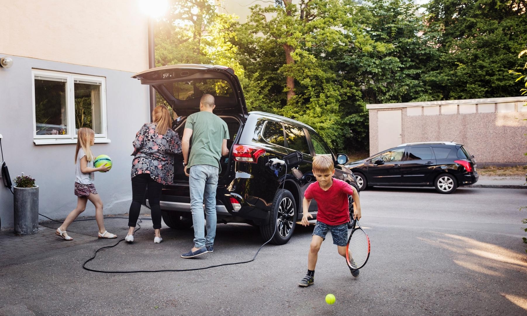 Eine Familie steht vor einem Elektroauto